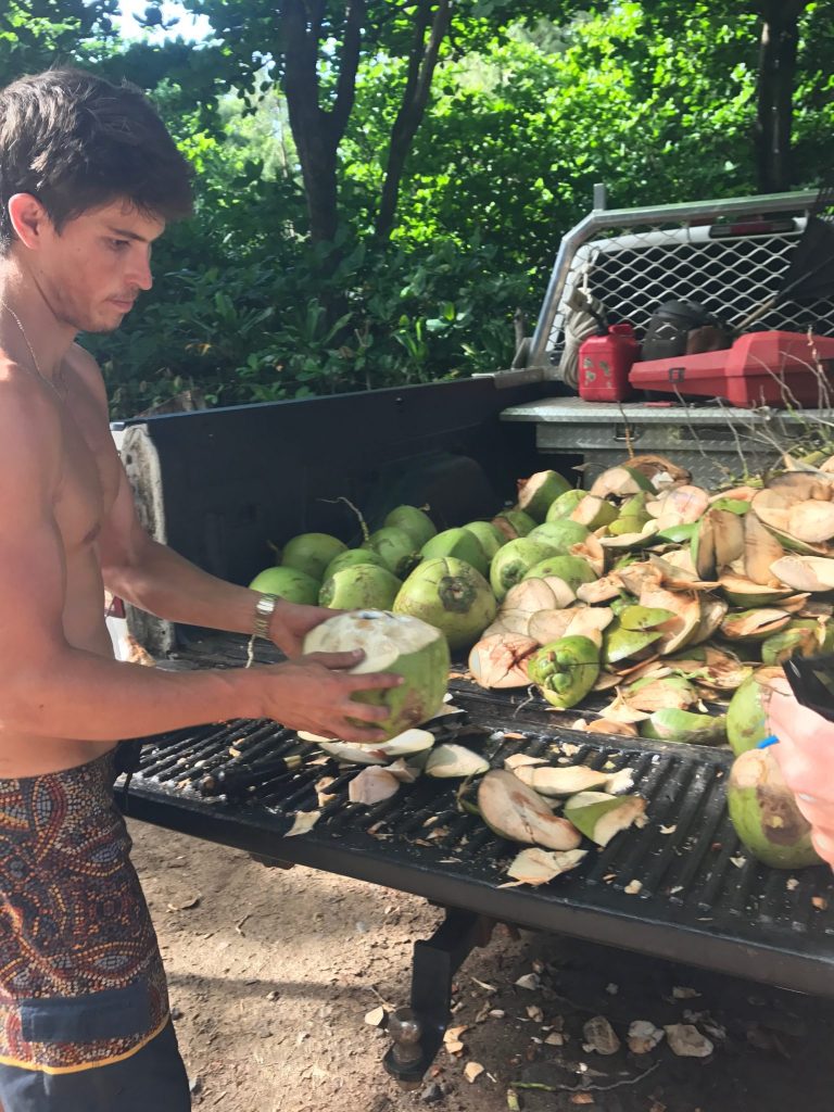 A man prepares a coconut at Ke'e Beach in Ha'ena State Park